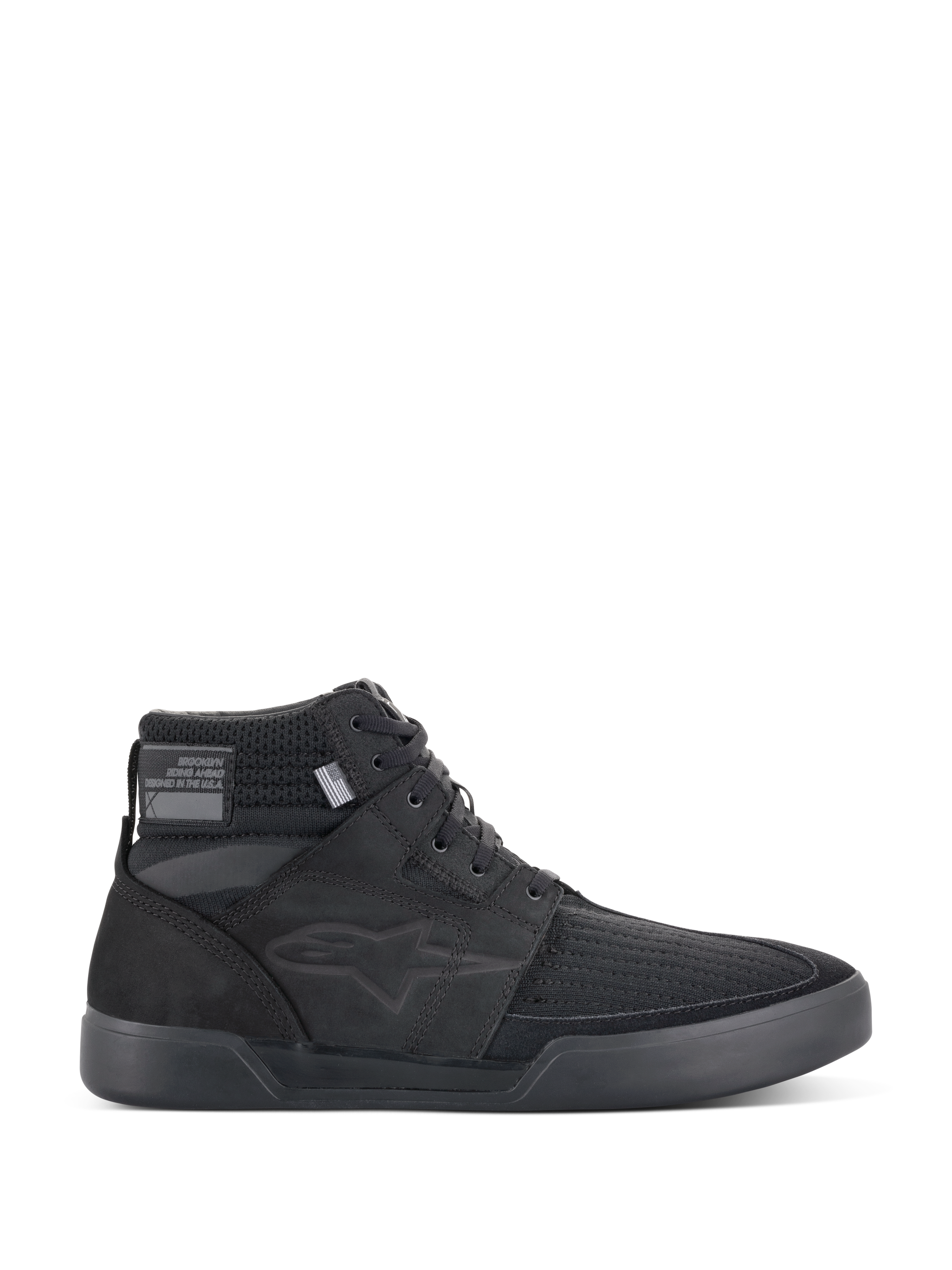 Alpinestars Primer Riding Shoes, sneaker da moto nere, calzature da guida urbana alte, vista laterale, tomaia in mesh testurizzato, suola in gomma spessa, design sportivo moderno con logo a stella discreto