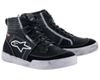 Scarpe Alpinestars Ageless, calzature da moto urbane, nero con cuciture e suole bianche a contrasto, silhouette sneaker alta con un grande logo a stella bianco sul lato, equipaggiamento protettivo casual per la guida su strada