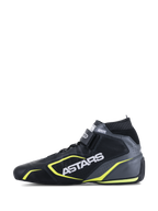Scarpe Alpinestars Tech-1 T V3 FIA, scarpe da auto racing, nero, grigio freddo e giallo fluo, vista laterale di profilo che mostra la costruzione in pelle, branding ASTARS bianco, colletto elastico ignifugo e vivaci accenti gialli.