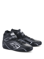 Alpinestars Tech-1 T V3 Shoes FIA, scarpe da auto racing, nero e argento, realizzazione in pelle bovina con loghi e branding Alpinestars argento, vista laterale angolata con chiusura a strappo e lacci