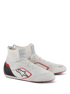 Scarpe Alpinestars Supertech, calzature per gare automobilistiche, bianco, rosso e nero, con tomaia interamente in maglia, coppa del tallone in fibra di carbonio nera e dettagli rossi sulla suola e sul logo, scarpe professionali da motorsport con etichette di certificazione FIA/SFI sulla linguetta.