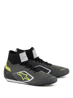 Scarpe Alpinestars Supertech, calzature da auto racing, grigio freddo e nero con accenti giallo fluo, caratterizzate da tomaia in maglia aramidica, tallone in fibra di carbonio ed etichette di certificazione FIA bianche sulla linguetta, design professionale da motorsport