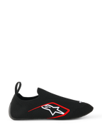 Scarpe Alpinestars Tech Gaming, scarpe da sim-racing, nero, profilo laterale che mostra la tomaia in maglia elasticizzata senza cuciture, logo Alpinestars a stella bianco con bordo rosso, passante posteriore, calzata simile a un calzino per corse virtuali