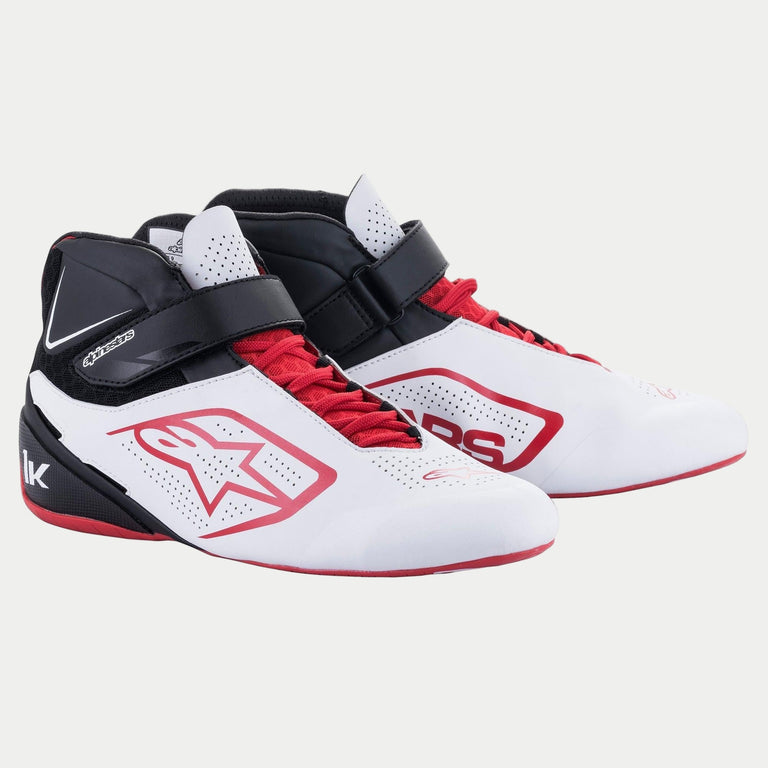 Scarpe Alpinestars Tech-1 K V2, scarpe da karting, bianco, nero e rosso, dotate di sistema di doppia chiusura con lacci rossi e cinturino a strappo nero, pannelli traforati per la traspirabilità, logo a stella Alpinestars rosso e profilo ergonomico per le corse.