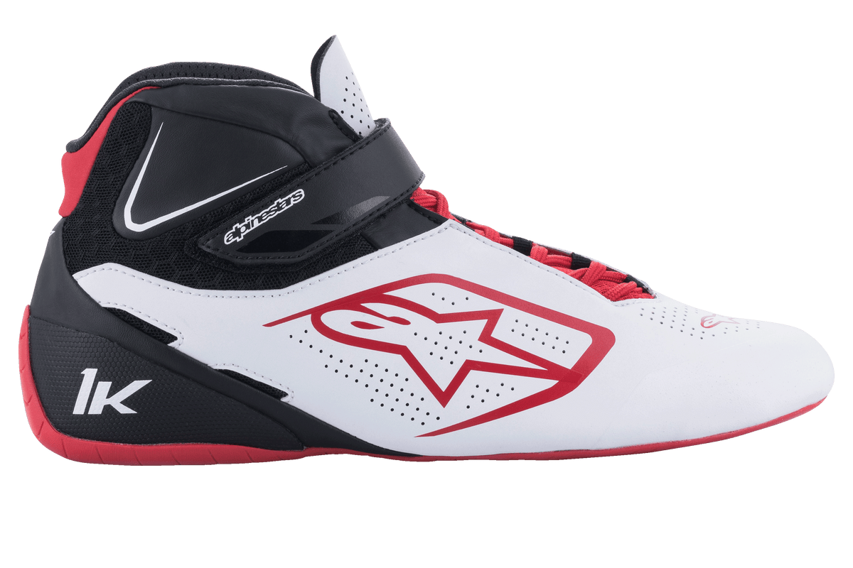 Scarpe Alpinestars Tech-1 K V2, scarpe da karting, bianco, nero e rosso, vista laterale con pannelli bianchi perforati, logo a stella rosso, cinturino alla caviglia nero e lacci rossi, calzature specializzate per motorsport