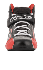 Scarpe Alpinestars Youth Tech-1 K, scarpe da karting, nero, bianco e rosso, vista frontale con lacci bianchi e cinturino a strappo con marchio, dettagli rossi sulla punta, struttura in microfibra leggera e mesh