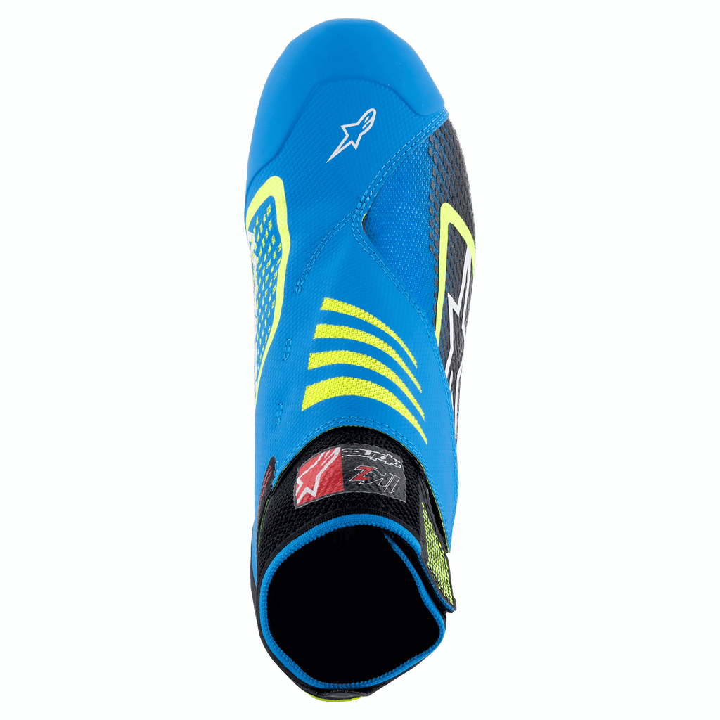 Scarpe Alpinestars Tech-1 KZ V2, scarpe da karting, nero, blu smalto e giallo fluo, vista dall'alto che mostra la tomaia in maglia senza cuciture, logo Alpinestars sulla punta e colletto elasticizzato per una vestibilità sicura