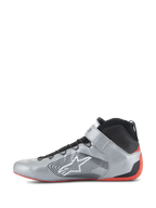 Scarpe Alpinestars Tech-1 Z V3 FIA, scarpe da corsa automobilistica, argento scuro, nero e rosso, profilo laterale di una scarpa da guida professionale, tomaia in pelle argento metallizzato con colletto in maglia nera, logo Alpinestars bianco e sottile suola in gomma rossa