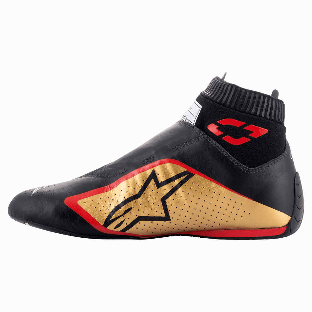 Scarpe Alpinestars Supermono V2 FIA, scarpe da corsa, nero, oro e rosso, vista di profilo caratterizzata da un'elegante costruzione in pelle monopezzo, pannello laterale oro con logo a stella nero, accenti rossi e colletto elastico a coste.