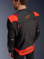 Giacca Alpinestars T-Stunt Air, nero, rosso fluo e rosso scuro, vista posteriore su un modello, mostra maniche in rete con protezioni per i gomiti con texture a nido d'ape, logo a stella Alpinestars sulla parte superiore della schiena e branding 'RACING AHEAD' sulla parte inferiore, design modulare a taglio sportivo per moto.