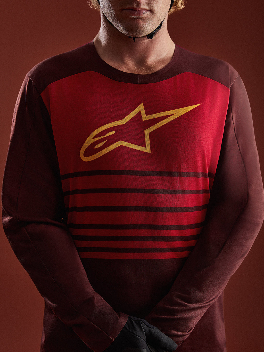 Alpinestars A-Dura Elite, maglia MTB bordeaux a maniche lunghe con pannello rosso, logo A-star giallo e strisce orizzontali.