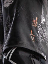 Pantaloncini A-Dura Ride Black Camo, dettaglio logo Alpinestars arancione su tessuto tecnico elasticizzato per MTB.