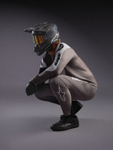Completo MTB Alpinestars A-Supra Elite grigio sfumato, maglia e pantaloni con casco integrale e maschera da gara.