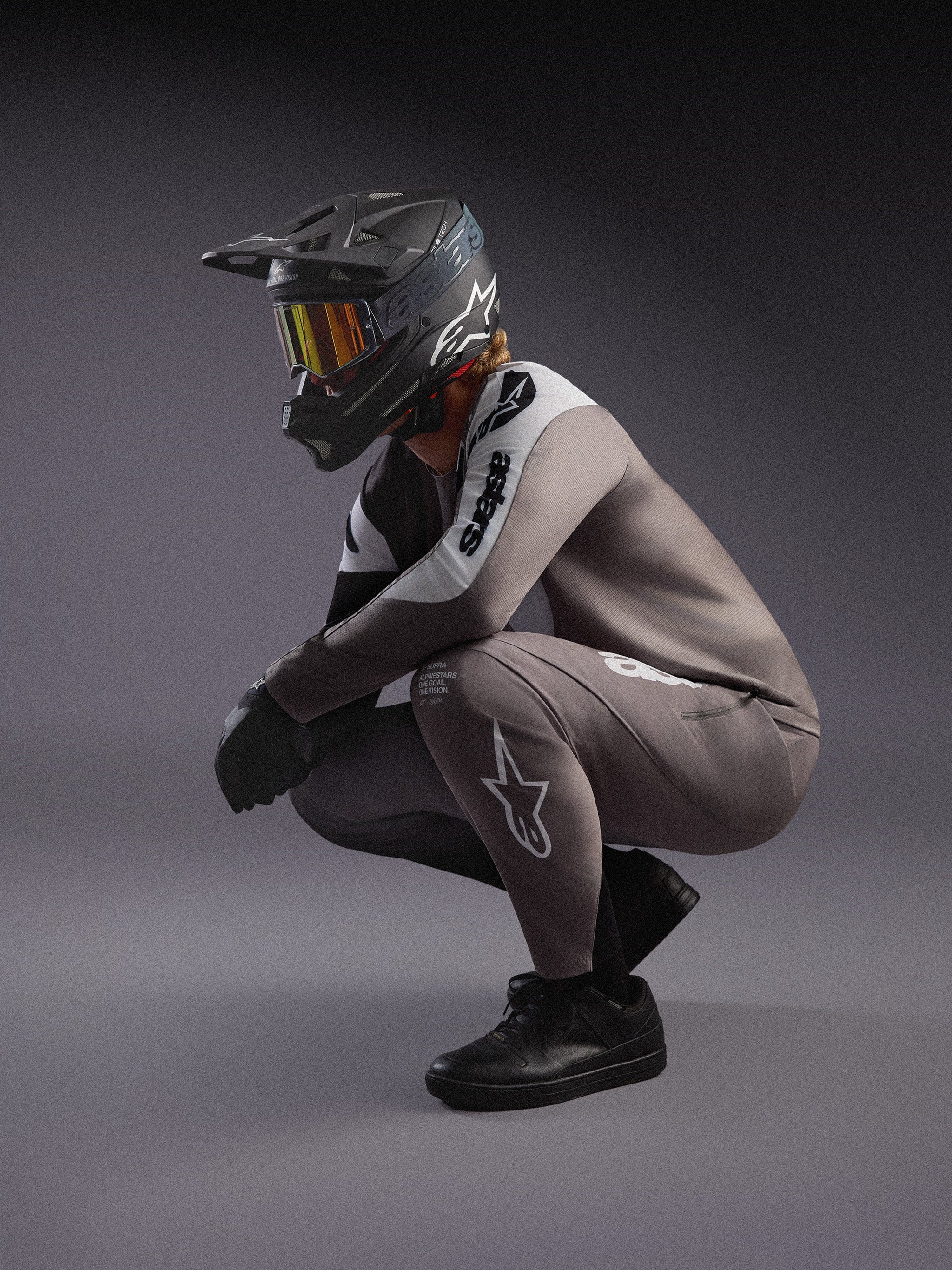 Completo MTB Alpinestars A-Supra Elite grigio sfumato, maglia e pantaloni con casco integrale e maschera da gara.
