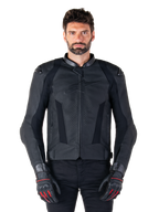 Alpinestars Missile V3 Leather Jacket, giacca da moto racing nera, indossata da un modello con guanti e pantaloni neri coordinati, caratterizzata da pelle traforata per la ventilazione, slider esterni sulle spalle e design sportivo aerodinamico