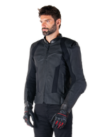 Motociclista con giacca in pelle Alpinestars Missile V3 in nero, in pregiata pelle bovina con pannelli traforati sul petto e protezioni esterne DFS sulle spalle, abbinata a pantaloni neri e guanti da corsa neri e rossi.