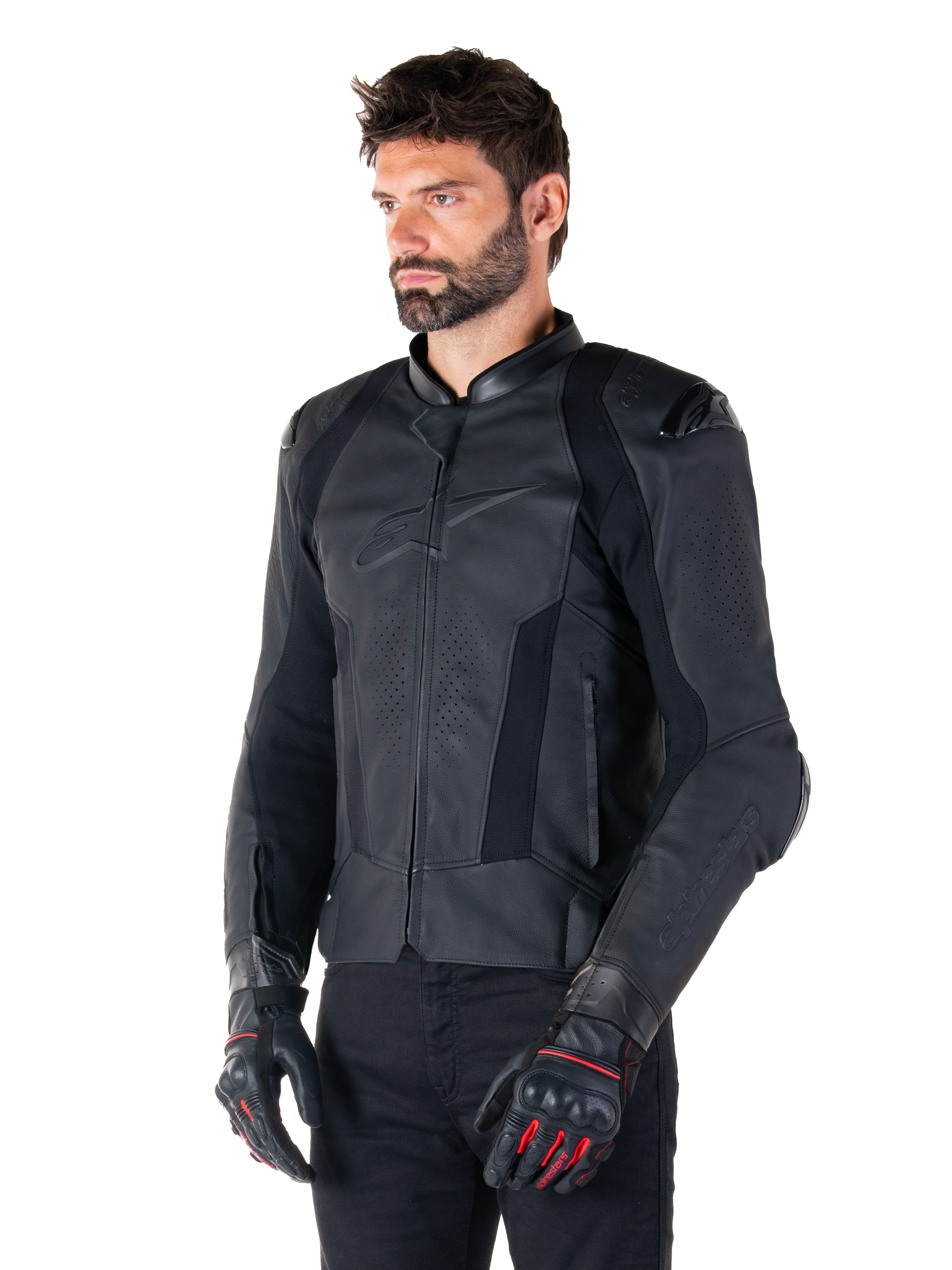 Motociclista con giacca in pelle Alpinestars Missile V3 in nero, in pregiata pelle bovina con pannelli traforati sul petto e protezioni esterne DFS sulle spalle, abbinata a pantaloni neri e guanti da corsa neri e rossi.