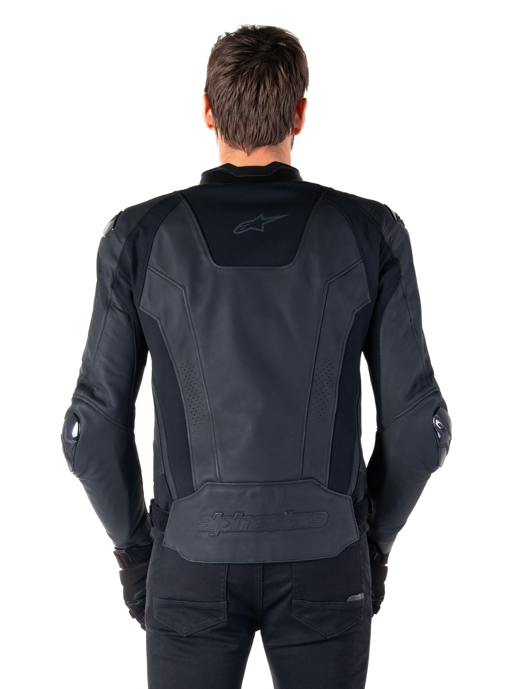 Vista posteriore di un pilota che indossa la giacca in pelle Alpinestars Missile V3 in nero, caratterizzata da una struttura in pelle pregiata con inserti tecnici elasticizzati, logo Alpinestars in rilievo sulla parte bassa della schiena e branding discreto sulla parte superiore, abbinata a pantaloni neri per un look sportivo da corsa coordinato.
