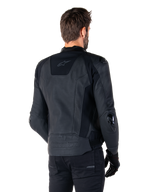 Giacca in pelle Alpinestars Missile V3, nera, vista posteriore su modello, giacca sportiva premium da corsa in pelle, con logo Alpinestars in rilievo sulla parte bassa della schiena e slider per i gomiti in TPU