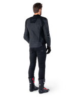 Alpinestars Missile V3 Leather Jacket in nero, vista posteriore su un pilota, indossata con pantaloni neri e stivali da corsa neri e rossi, caratterizzata da una struttura in pelle con branding tono su tono e vestibilità racing performante