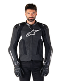 Giacca in pelle Alpinestars Missile V3, nera con loghi bianchi, indossata da un modello con guanti da moto neri, giacca da corsa in pelle premium con pannelli di ventilazione traforati e caratteristiche per prestazioni di guida