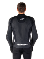 Vista posteriore della giacca in pelle Alpinestars Missile V3 in nero e bianco, con logo Alpinestars a stella sulla parte superiore della schiena e marchio sulla zona lombare, strisce verticali bianche e slider esterni sui gomiti, giacca sportiva da corsa in pelle premium.