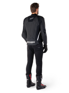 Giacca in pelle Alpinestars Missile V3, nera e bianca, vista posteriore sul pilota, con marchio Alpinestars bianco sulla parte inferiore della schiena e piccolo logo sulla parte superiore, indossata con pantaloni neri e stivali da corsa, costruzione in pelle premium per gare motociclistiche