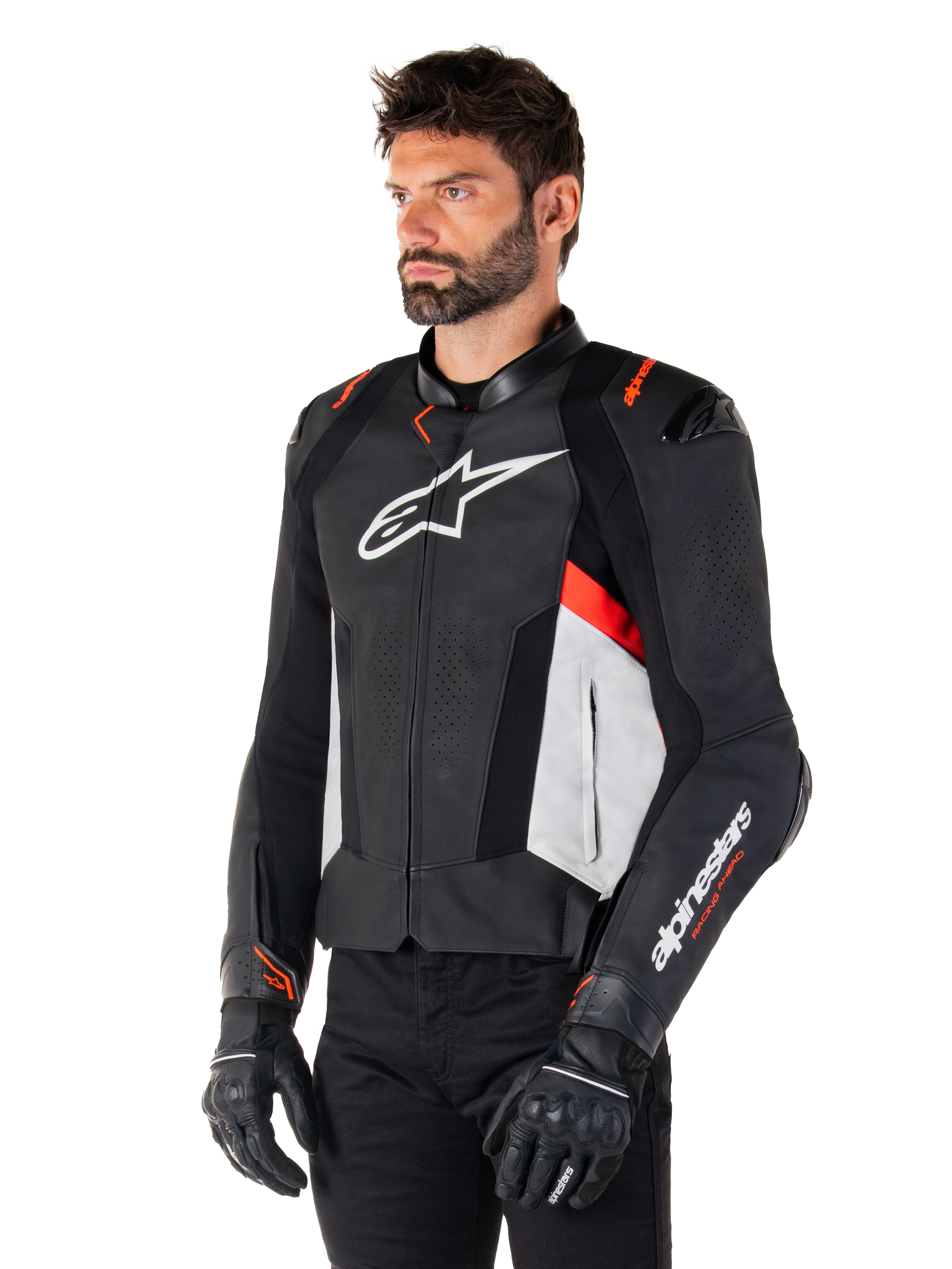 Giacca in pelle Alpinestars Missile V3, nero, bianco e rosso fluo, giacca da moto sportiva da corsa indossata da un modello con guanti e pantaloni neri, caratterizzata da pannelli in pelle traforata e branding Alpinestars in evidenza