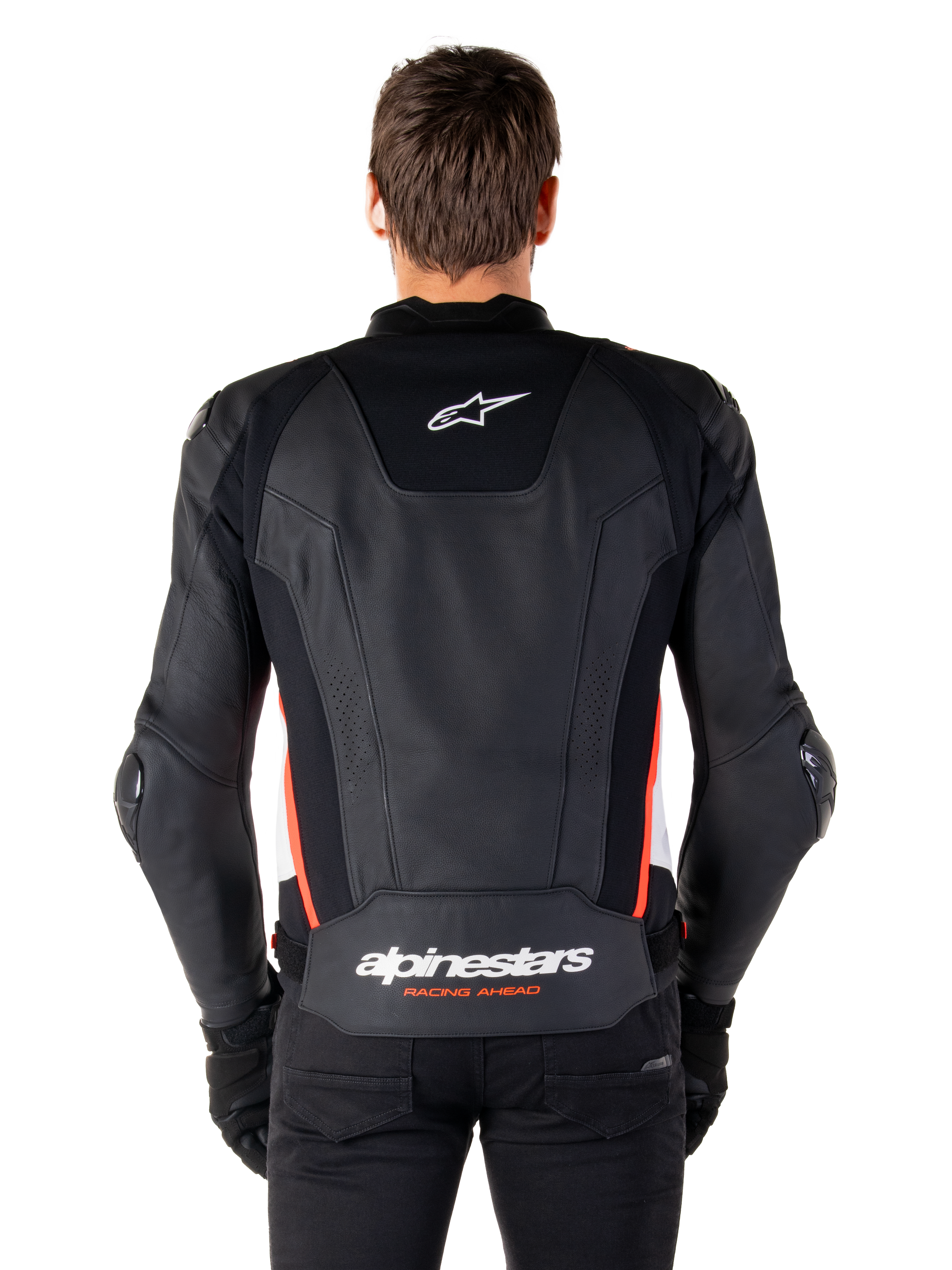 Giacca in pelle Alpinestars Missile V3, vista posteriore, in pregiata pelle nera con dettagli rosso fluo e bianchi, logo a stella bianco sulla parte superiore e scritta Alpinestars in basso, indossata con pantaloni e guanti neri
