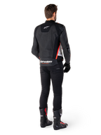 Alpinestars Missile V3 Leather Jacket in Nero Bianco Rosso Fluo, vista posteriore su un pilota uomo, con marchio Alpinestars sulla parte superiore e inferiore della schiena, abbinata a pantaloni neri e stivali da moto, giacca sportiva in pelle d'ispirazione racing.