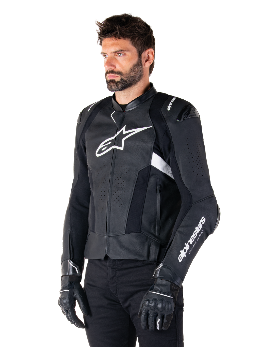 Uomo che indossa la giacca in pelle Alpinestars Missile V3 Airflow, giacca da moto in nero e bianco, pelle pregiata traforata per il flusso d'aria, logo Alpinestars bianco su petto e manica, vestibilità sportiva ispirata alle corse, indossata con guanti e pantaloni neri.