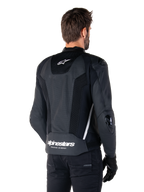 Alpinestars Missile V3 Airflow Leather Jacket, nero e bianco, vista posteriore con pelle traforata e pannelli in rete per la massima ventilazione, marchio Alpinestars bianco sulla parte inferiore della schiena e logo a stella sul collo, indossata con abbigliamento da moto nero, design sportivo racing premium.