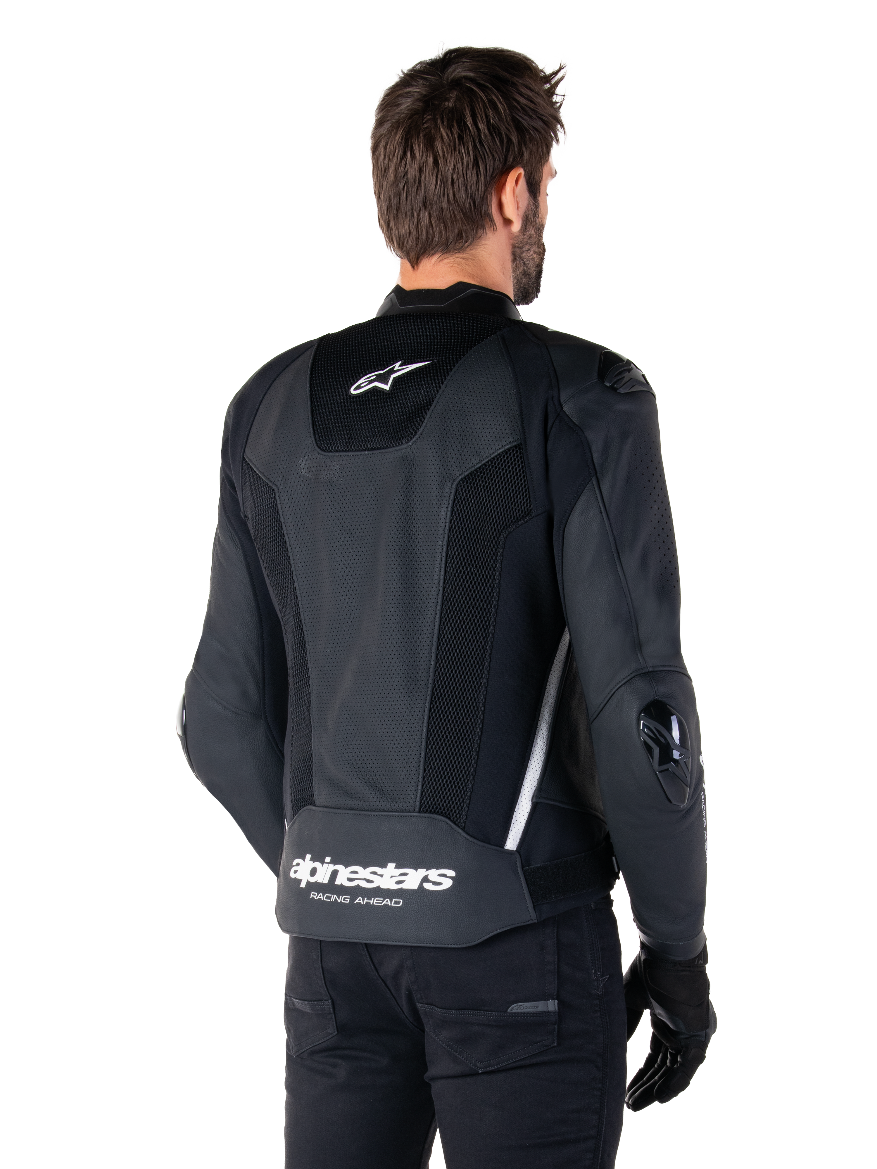 Alpinestars Missile V3 Airflow Leather Jacket, nero e bianco, vista posteriore con pelle traforata e pannelli in rete per la massima ventilazione, marchio Alpinestars bianco sulla parte inferiore della schiena e logo a stella sul collo, indossata con abbigliamento da moto nero, design sportivo racing premium.