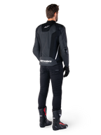Alpinestars Missile V3 Airflow Leather Jacket, nero e bianco, vista posteriore indossata con pantaloni tecnici neri e stivali da corsa, caratterizzata da pannelli posteriori in pelle traforata e logo Alpinestars sulla parte bassa della schiena.