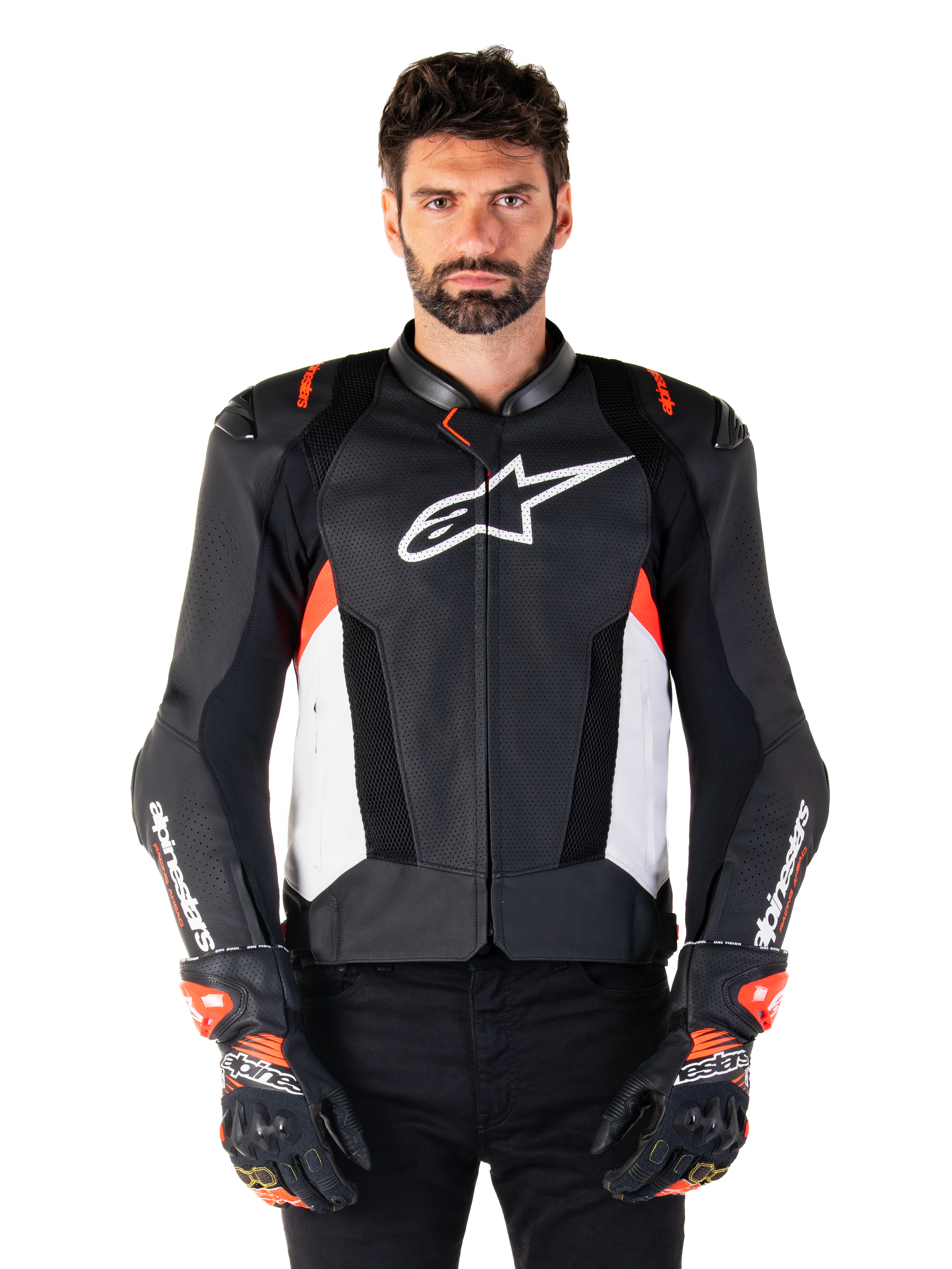 Giacca Alpinestars Missile V3 Airflow in pelle, giacca da moto racing, nero e bianco con accenti rosso fluo, pannelli di ventilazione traforati, logo stella bianco sul petto, indossata con guanti neri e rossi, costruzione in pelle pregiata