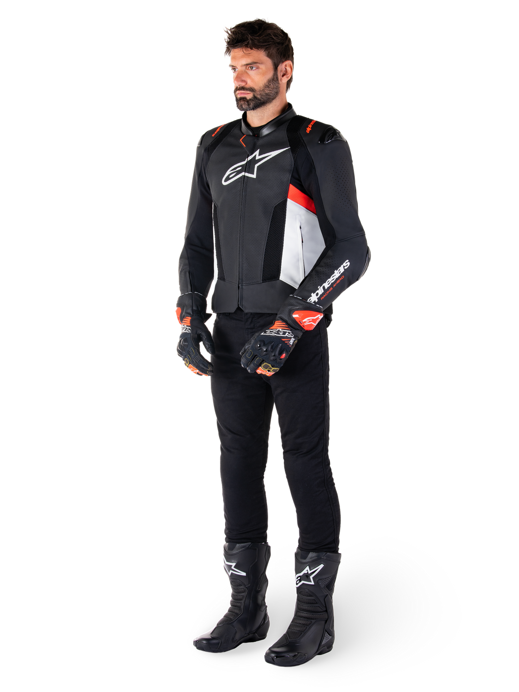 Giacca in pelle Alpinestars Missile V3 Airflow, nero bianco rosso fluo, indossata da un modello con pantaloni neri, guanti da corsa neri e stivali neri, caratterizzata da pelle traforata per la ventilazione, logo bianco sul petto e accenti rosso fluo, progettata per prestazioni racing e sportive di alto livello.