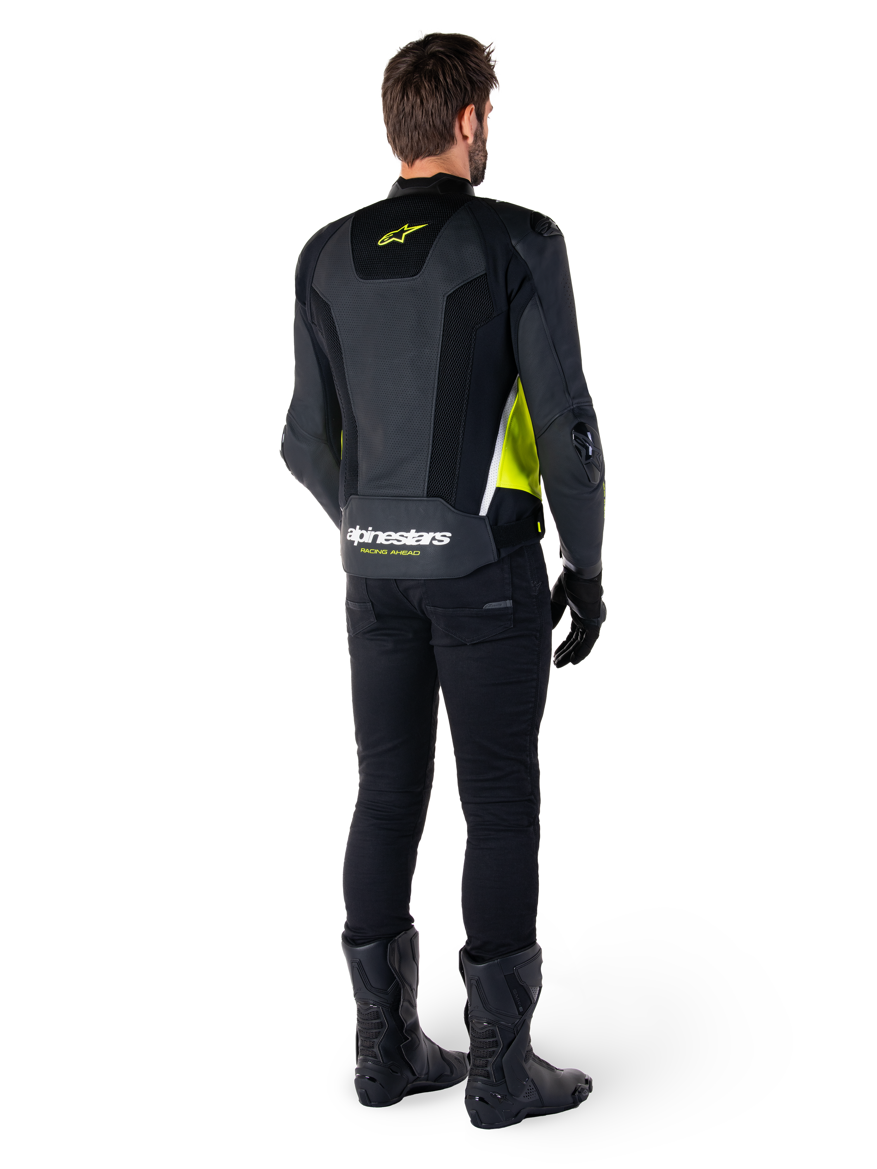 Giacca in pelle Alpinestars Missile V3 Airflow, nero, giallo fluo e bianco, vista posteriore sul pilota, con pannelli posteriori in pelle traforata, logo Alpinestars giallo e dettagli bianchi, indossata con pantaloni e stivali da moto neri