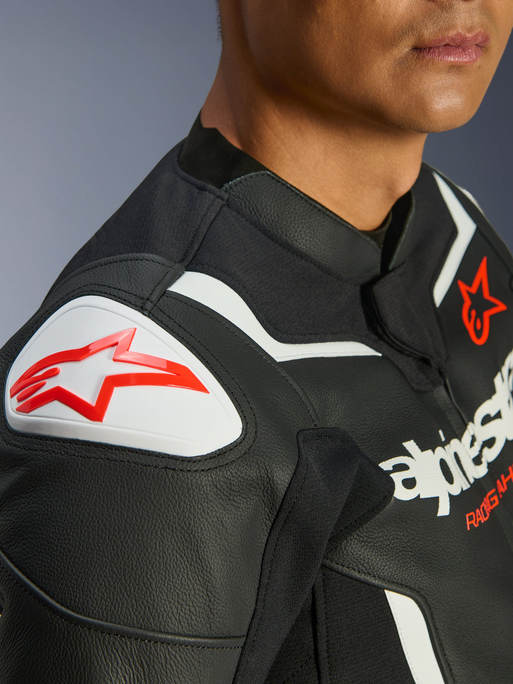 Giacca in pelle Alpinestars GP Force V2, nero e bianco, primo piano della protezione per spalle GP Lite Evo DFS con logo Alpinestars rosso, costruzione multi-pannello in pregiata pelle bovina, pannelli elasticizzati integrati per una guida performante