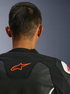 Alpinestars GP Force V2 Leather Jacket, nero e bianco, vista ravvicinata posteriore di collo e spalle, logo Alpinestars rosso, pelle premium con pannelli elasticizzati in tessuto, design sportivo ad alte prestazioni