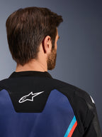 Alpinestars GP Force V2 Leather Jacket, vista ravvicinata posteriore del collo e delle spalle, logo Astars bianco su pannello nero, costruzione in pelle blu con accenti rosso fluorescente e azzurro, abbigliamento sportivo da moto
