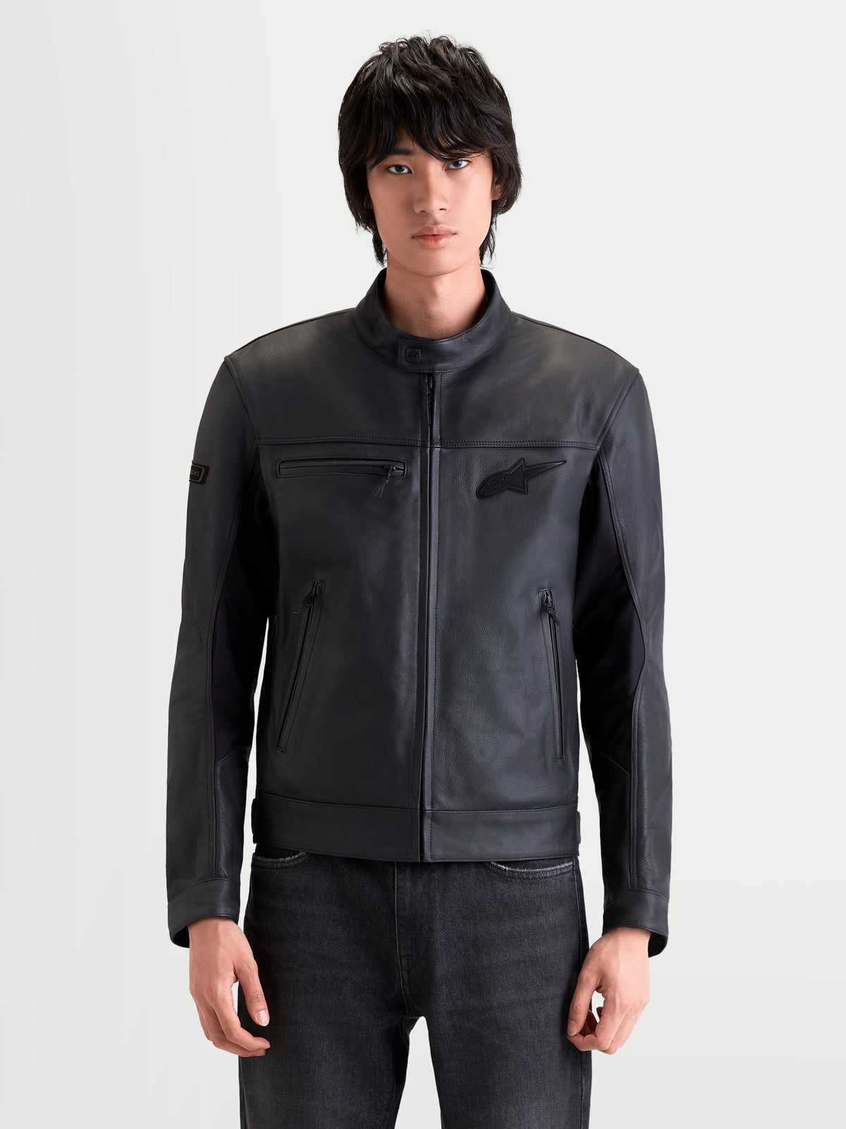 Alpinestars Maver X Giacca di pelle, giacca da moto urbana contemporanea da uomo in pelle nera, vista frontale su un modello che indossa una giacca in pregiata pelle bovina con inserti elasticizzati