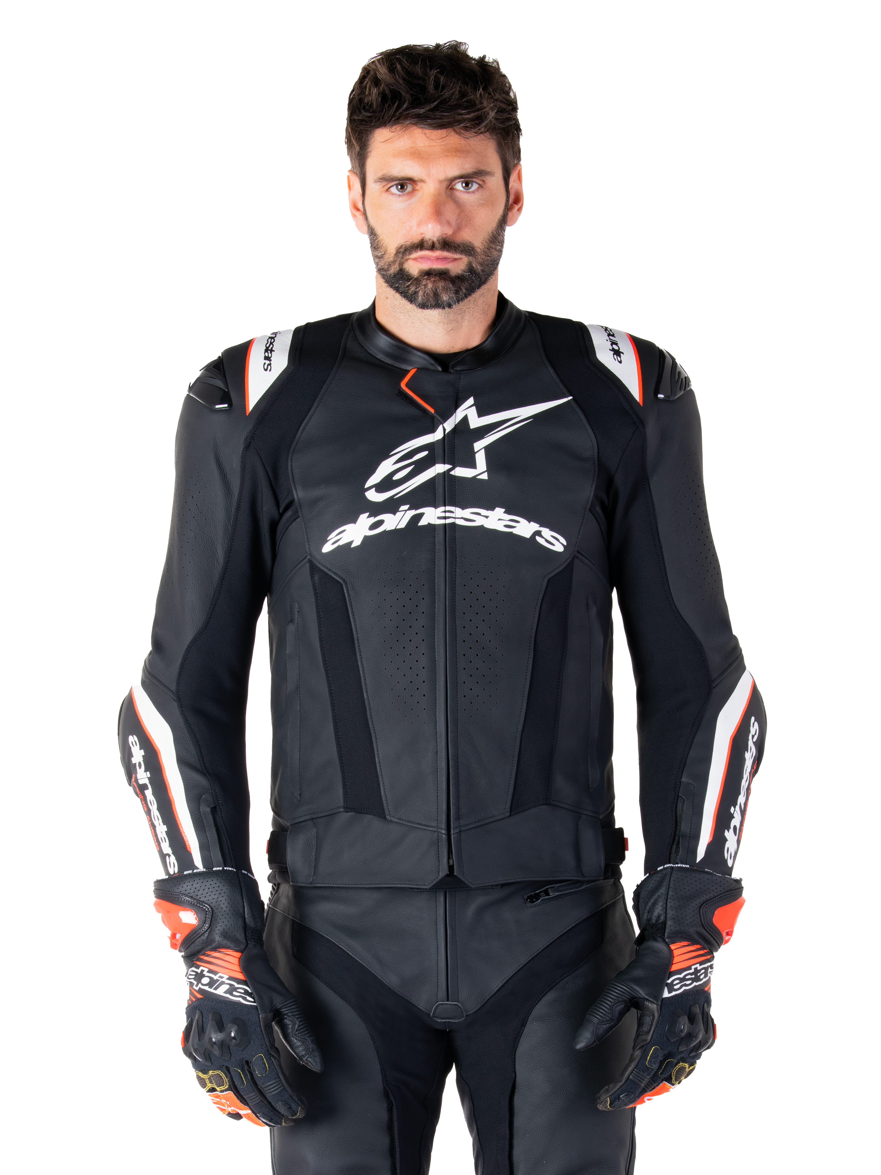 Giacca in pelle Alpinestars Missile V3 Ignition, nero con accenti bianchi e rossi, indossata da un modello con guanti e pantaloni da corsa coordinati, giacca da moto sportiva derivata dalla MotoGP con branding evidente