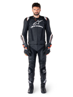 Pilota che indossa la giacca in pelle Alpinestars Missile V3 Ignition nera, abbinata a pantaloni in pelle, guanti e stivali coordinati, con marchio Alpinestars bianco e dettagli rossi, progettata per prestazioni da corsa professionali.