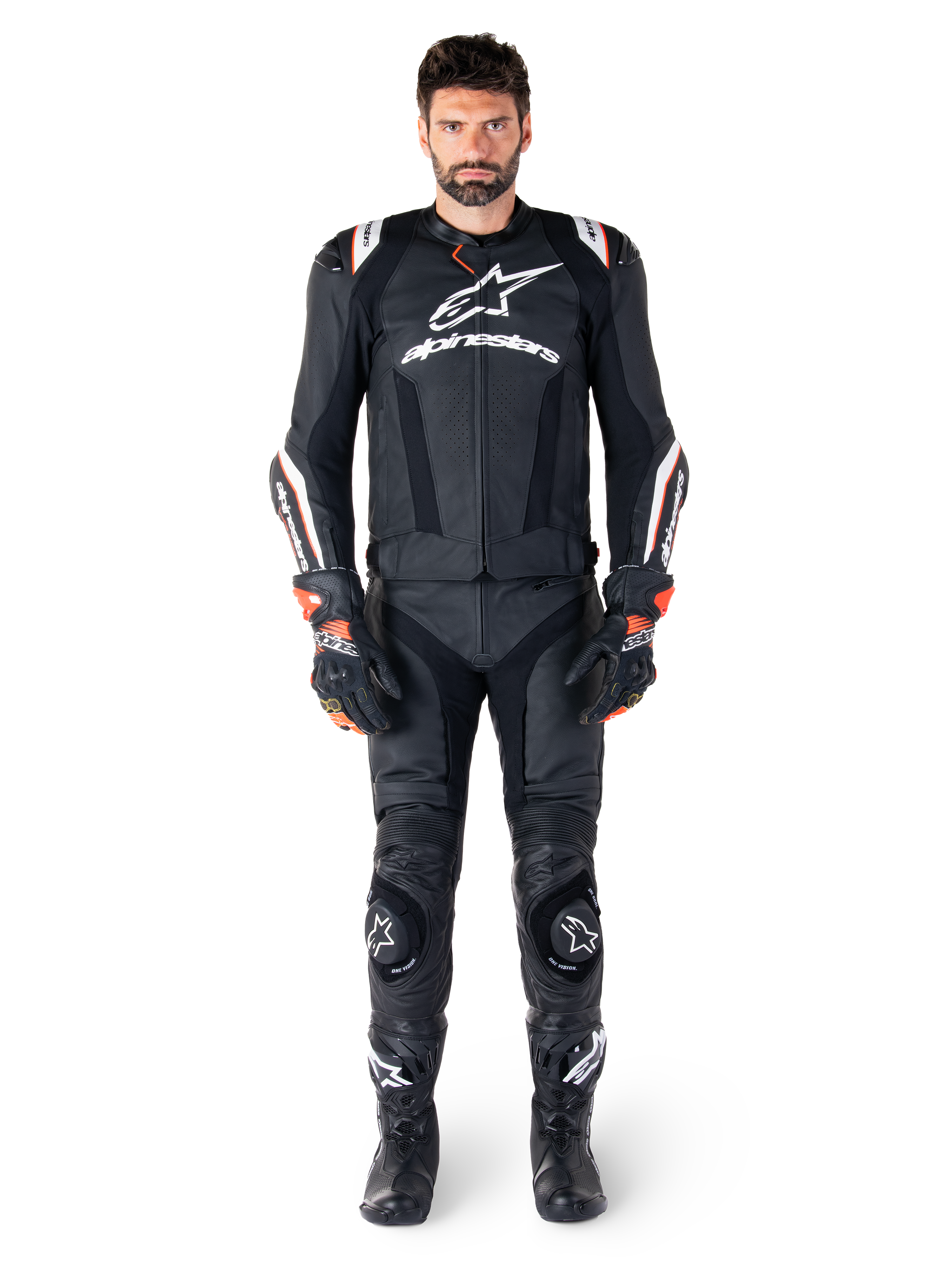 Pilota che indossa la giacca in pelle Alpinestars Missile V3 Ignition nera, abbinata a pantaloni in pelle, guanti e stivali coordinati, con marchio Alpinestars bianco e dettagli rossi, progettata per prestazioni da corsa professionali.