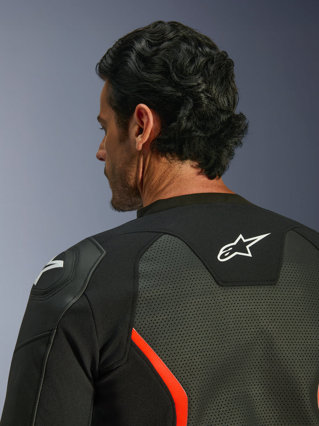 Giacca in pelle Alpinestars GP Force V2 Air, nero e rosso fluo, primo piano della parte superiore della schiena e della spalla, con ampie perforazioni della pelle per il flusso d'aria, logo bianco sulla schiena e protezione per la spalla GP Lite Evo