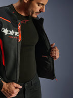 Giacca in pelle Alpinestars GP Force V2 Air, nero e rosso fluo, aperta per mostrare la tasca impermeabile interna e il marchio, costruzione multi-pannello in pelle traforata per il flusso d'aria, indossata con base layer Alpinestars nero