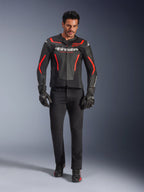 Pilota con giacca in pelle Alpinestars GP Force V2 Air, nero e rosso fluo, abbinata a jeans da moto neri, guanti e scarpe, con pelle traforata, logo bianco e accenti rossi per un look sportivo