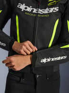 Giacca in pelle Alpinestars GP Force V2 Air, Nero Giallo Fluo, primo piano della struttura in pelle traforata e dettagli ad alta visibilità, con branding prominente e grafica 'RACING AHEAD', design sportivo per prestazioni motociclistiche