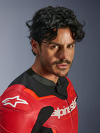 Giacca in pelle Alpinestars GP Force V2 Air, rosso e rosso fluo, indossata da un uomo in un ritratto ravvicinato, caratterizzata da pelle bovina traforata, logo Alpinestars bianco sul petto e sulla spalla e dettagli in tessuto nero, abbigliamento professionale da corsa motociclistica
