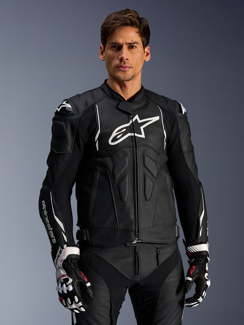 Alpinestars Dusk Leather Jacket, Black and White, leather motorcycle jacket with padded protection areas and white logos, worn with black and white racing gloves featuring red accents, professional sport riding gear